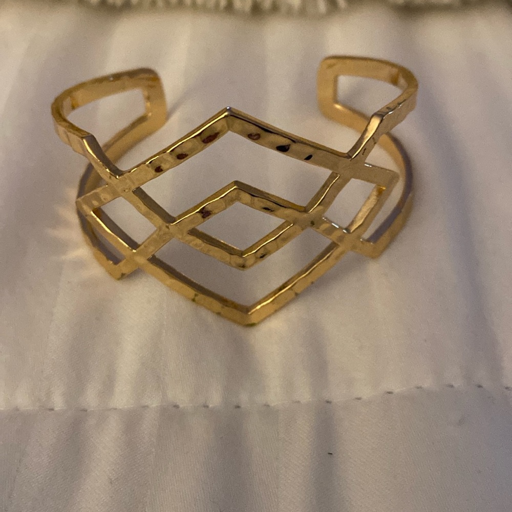 Gold tone cuff bracelet.